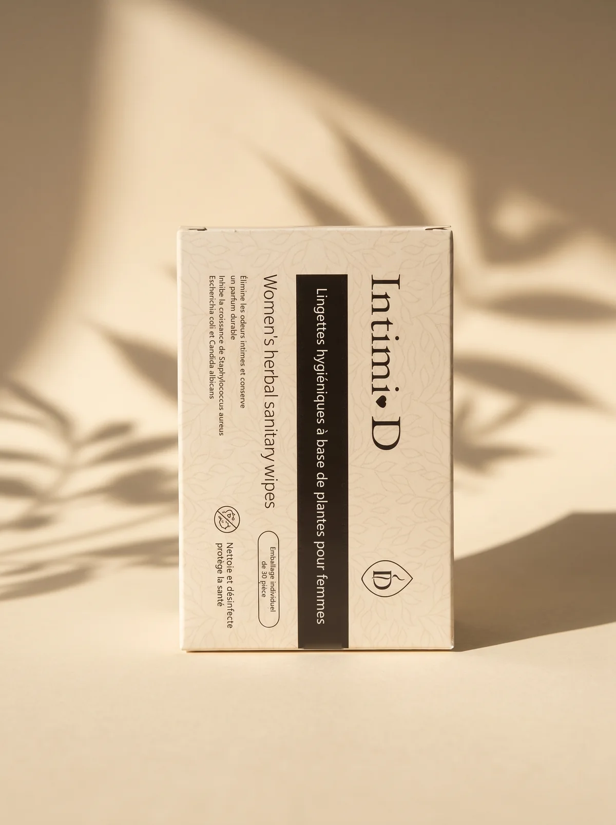 La boîte de lingettes Intimi-D dans la lumière, ombres de feuillage
