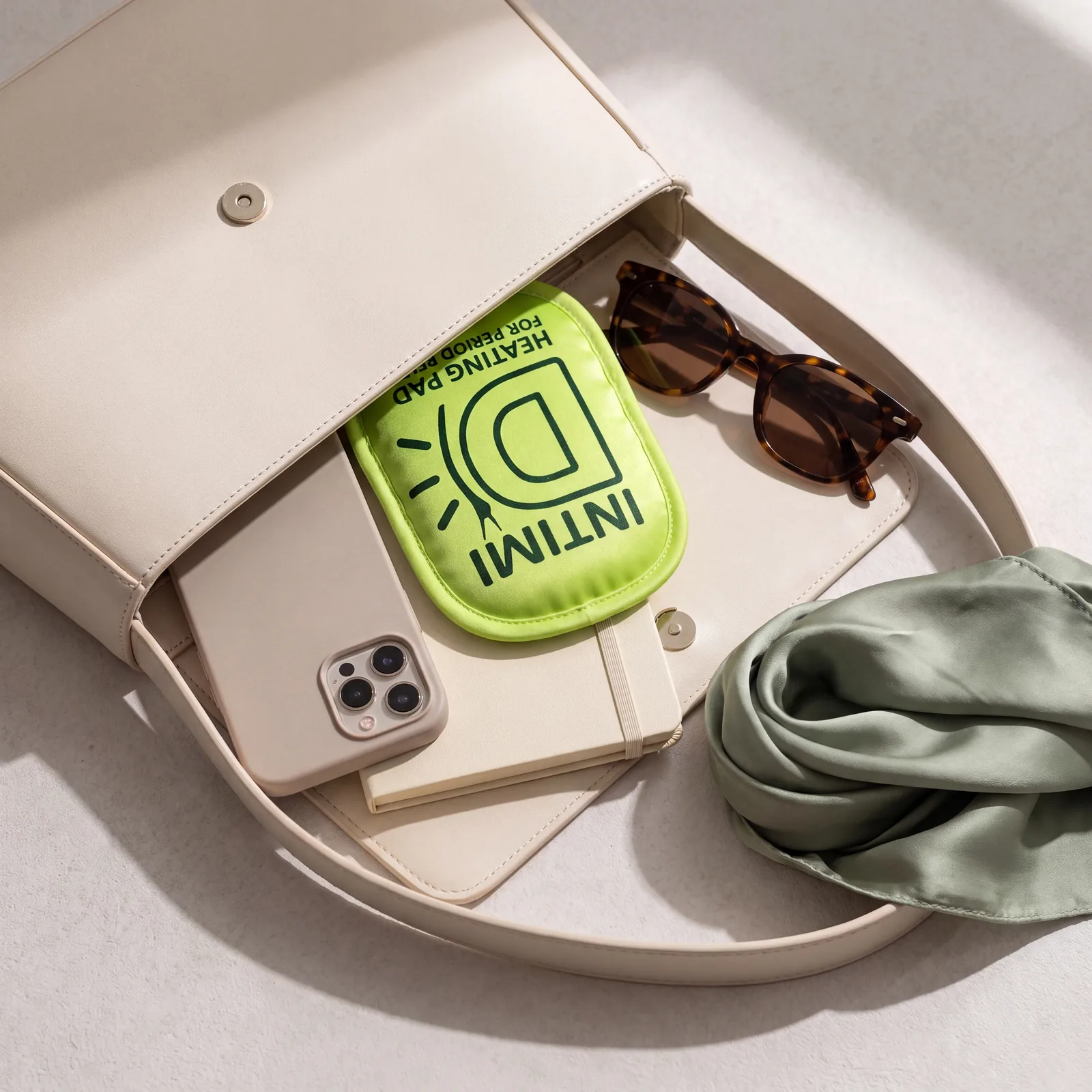 Le patch Intimi-D glissé dans un sac à main, à côté d'un téléphone